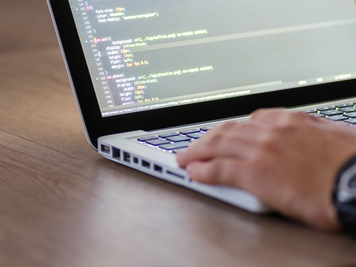 Persoon aan het programmeren op een laptop